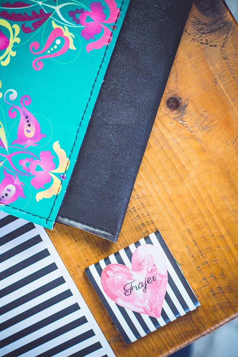 Detalj — šarena Frajer torbica i prugasta kartica na drvenom stolu