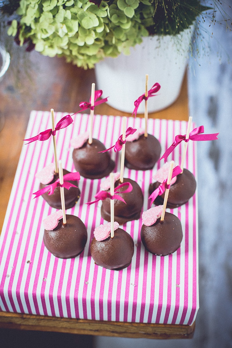 Čokoladni cake pops sa roze mašnicama na prugastom papiru