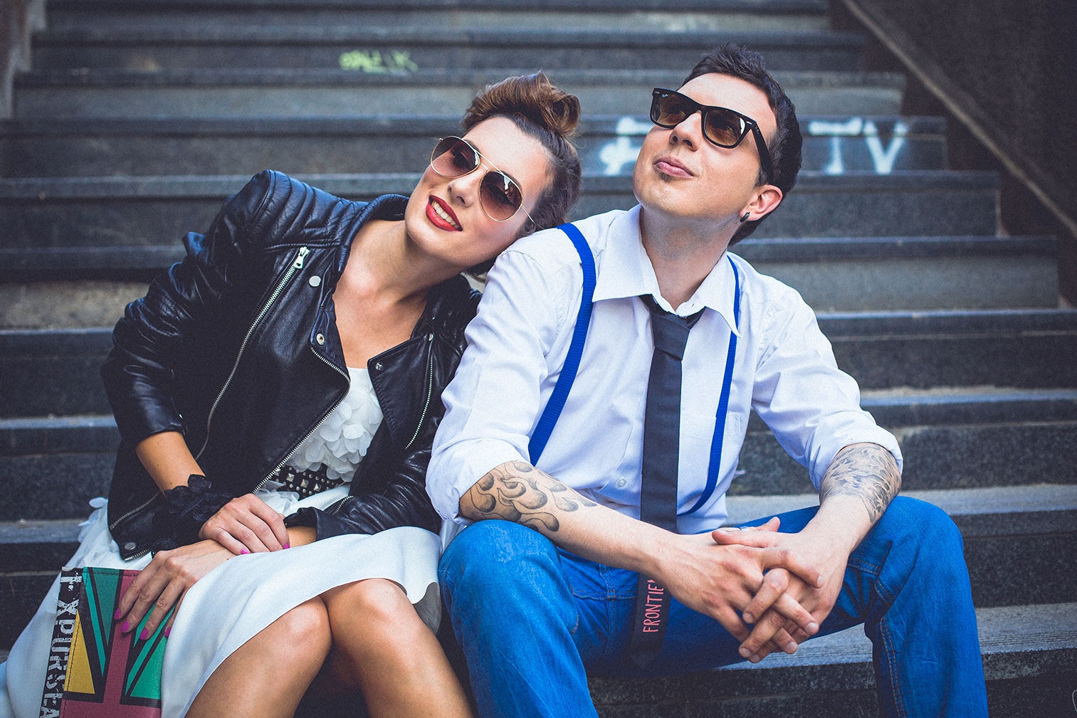 Par sedi na kamenim stepenicama sa naočarima — opušteni urbani portret