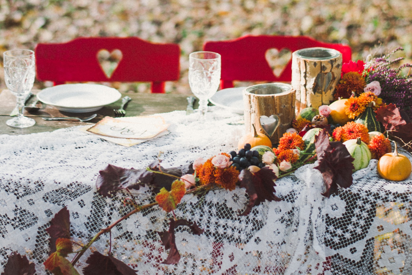 Detalji dekoracije — grožđe i hrizanteme na heklanom stolnjaku