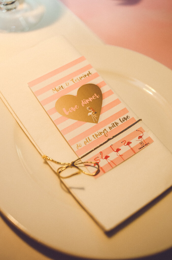 Detalj zlatnog srca i roze ruže na stolu za večeru