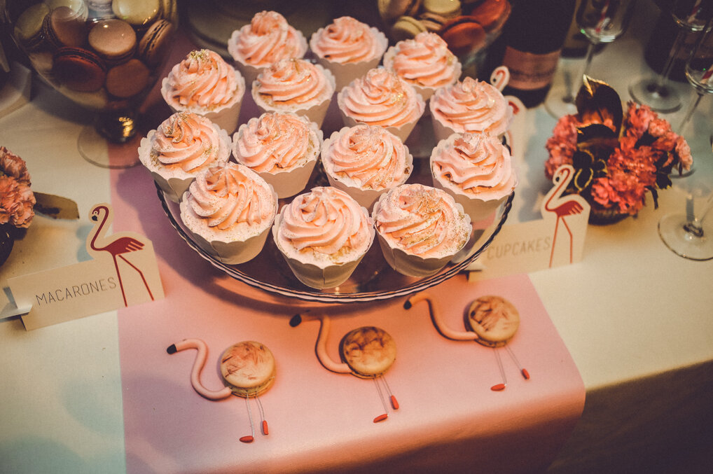 Roze cupcakes sa zlatnim posipom i flamingo makaronsi na pink podlozi